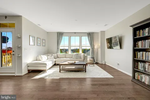 a kitchen with stainless steel appliances refrigerator wooden floor dining table and chairs