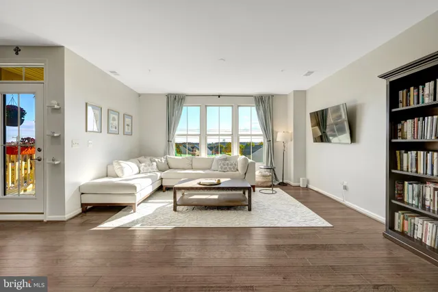 a kitchen with stainless steel appliances refrigerator wooden floor dining table and chairs