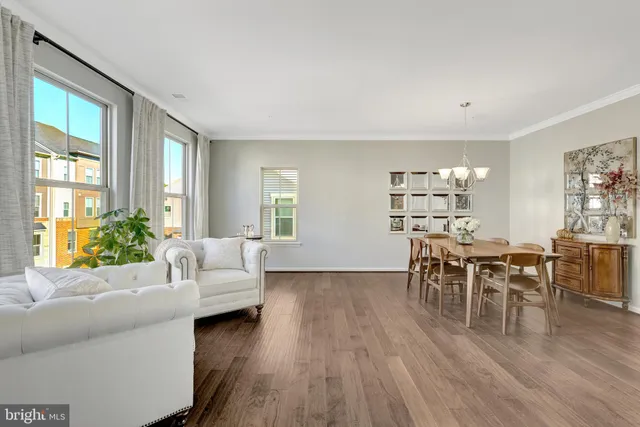 a living room with furniture wooden floor and a large window