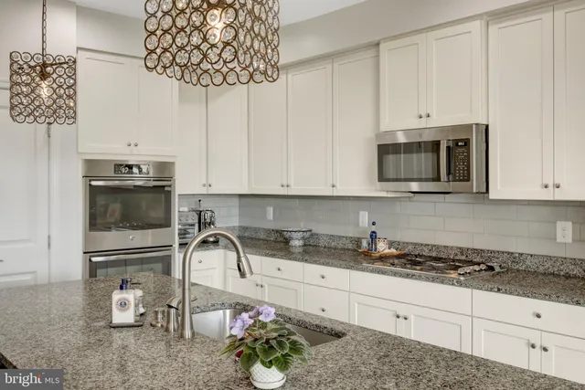 a kitchen with stainless steel appliances granite countertop a sink a stove and a microwave