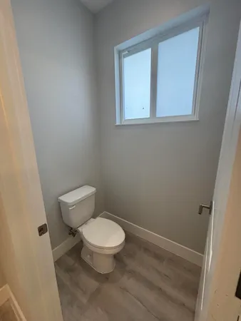 a white toilet sitting next to a bathroom sink and vanity