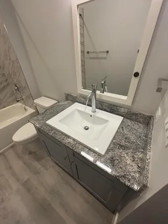a bathroom with a granite countertop sink and a mirror