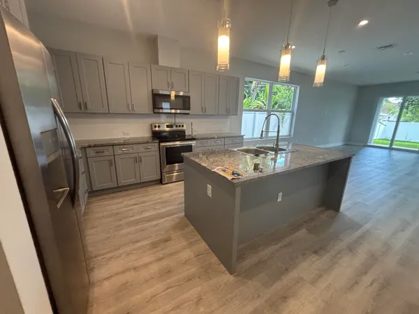 a kitchen with a sink a stove a refrigerator and a window