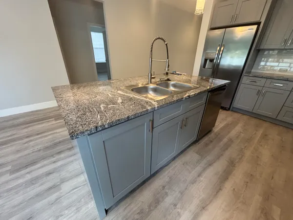 a kitchen with sink and mirror