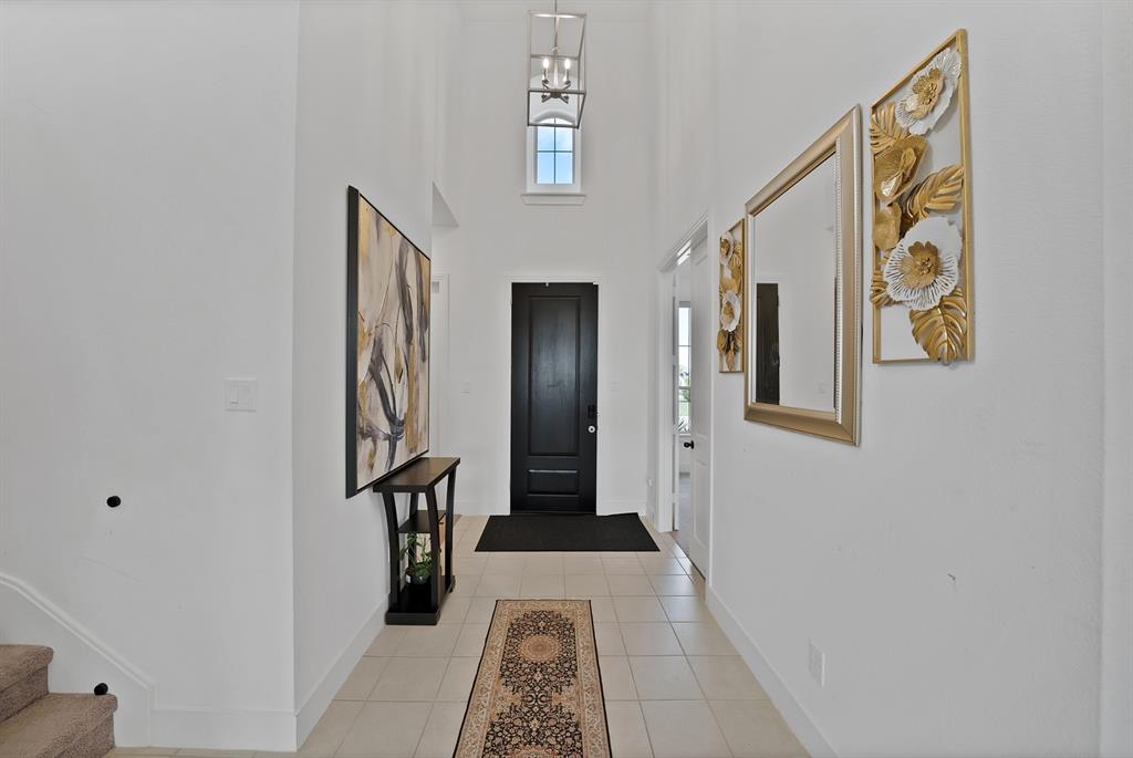 4222 Crown Run Road Midlothian, TX 76065 - Photo 14 of 40 Two-story entryway featuring a black panel door, a black console table, and a contemporary pendant light fixture