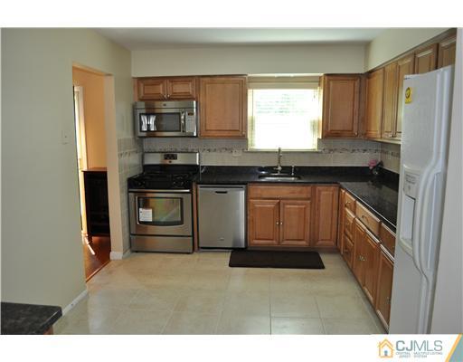 7104 Hana Road Edison, NJ 08817 - Photo 4 of 10 a kitchen with granite countertop a sink stove and refrigerator