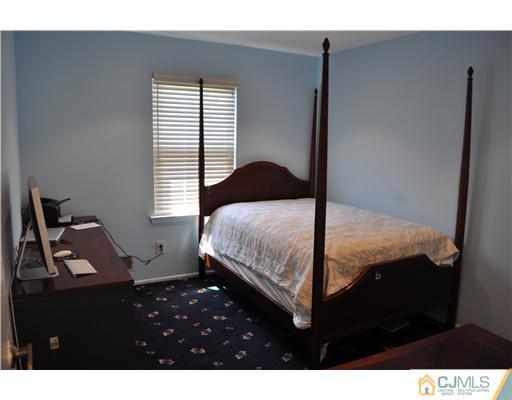 7104 Hana Road Edison, NJ 08817 - Photo 7 of 10 a bedroom with a bed window and a night stand