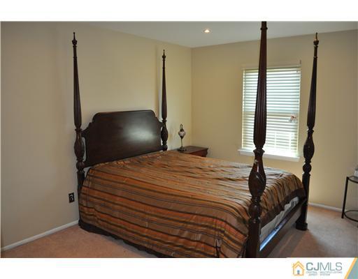 7104 Hana Road Edison, NJ 08817 - Photo 8 of 10 a bedroom with a bed and two mirror