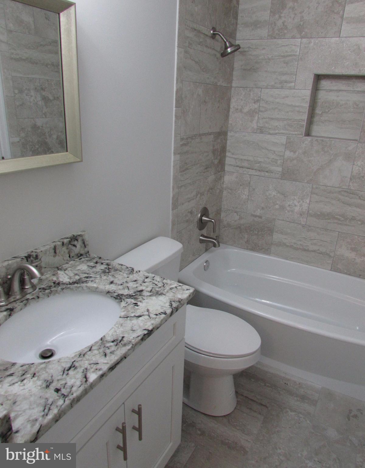 2029 South Glebe Road Arlington, VA 22206 - Photo 10 of 14 a bathroom with a granite countertop toilet a sink and a bathtub