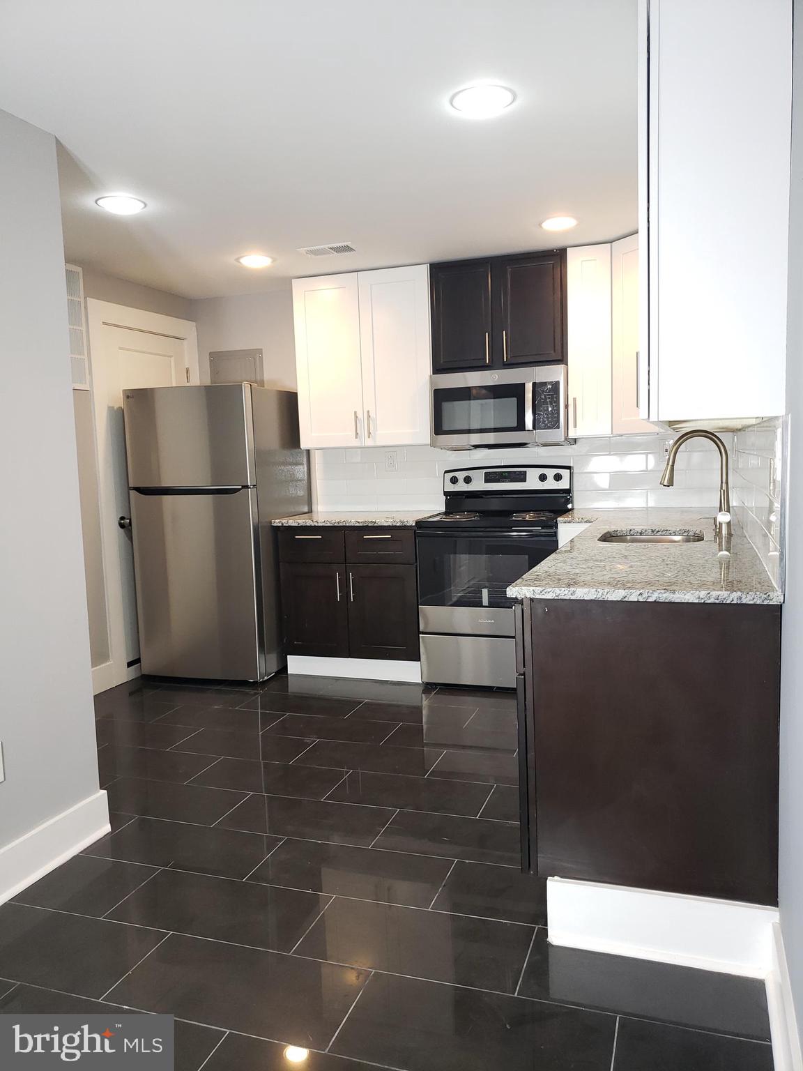 2001 South 17th Street, Unit 3 Philadelphia, PA 19145 - Photo 5 of 13 a kitchen with a sink a stove a refrigerator a microwave and cabinets