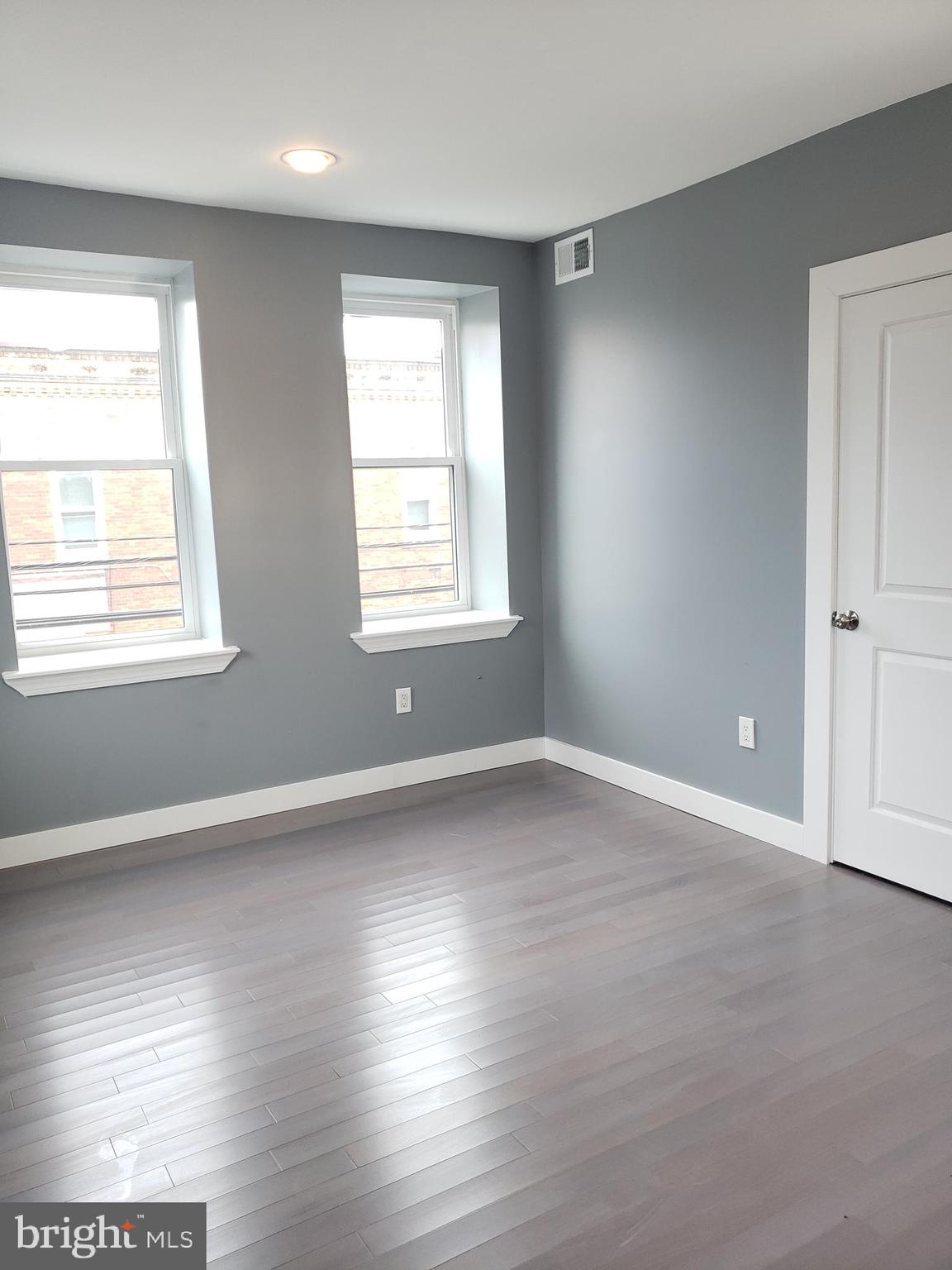 2001 South 17th Street, Unit 3 Philadelphia, PA 19145 - Photo 7 of 13 an empty room with wooden floor and windows