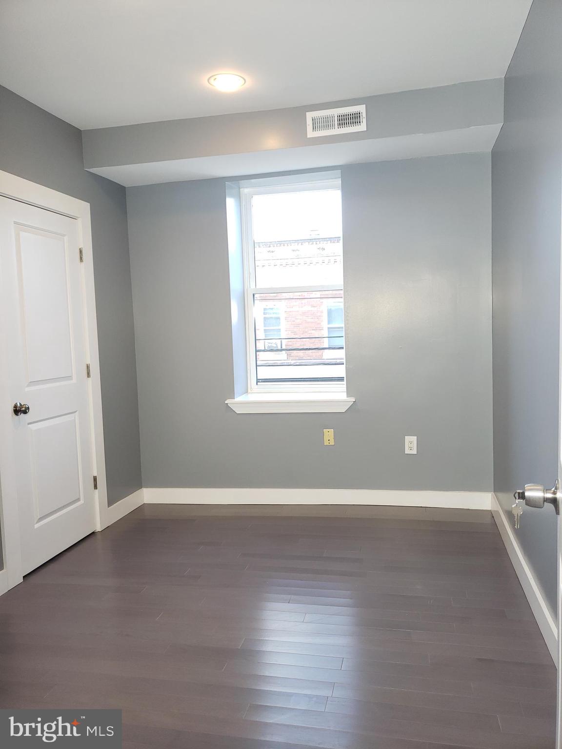 2001 South 17th Street, Unit 3 Philadelphia, PA 19145 - Photo 9 of 13 an empty room with wooden floor and windows
