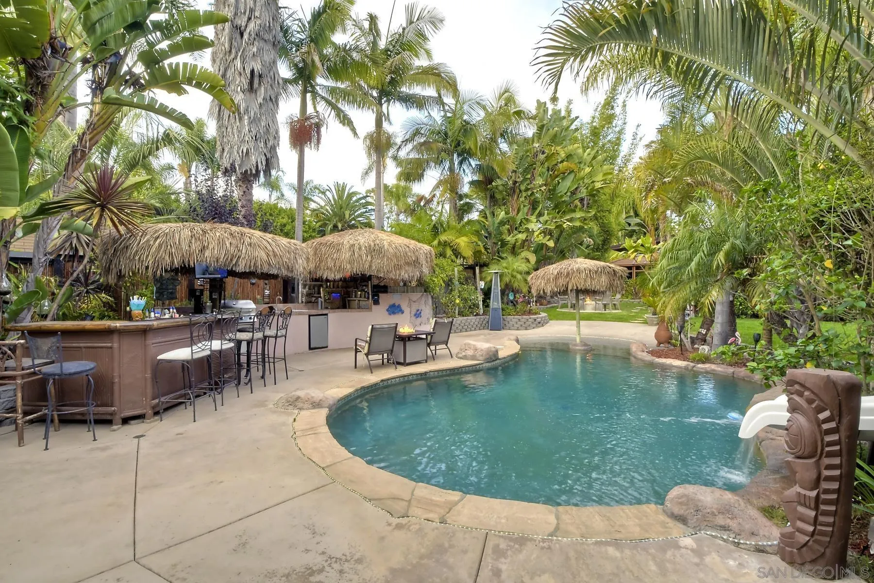 536 Saxony Road Encinitas, CA 92024 - Photo 9 of 57 a view of a swimming pool with lawn chairs under an umbrella