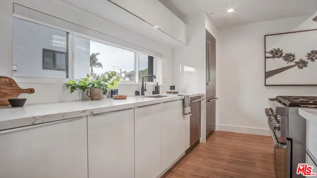a kitchen with stainless steel appliances a sink a counter top space and cabinets