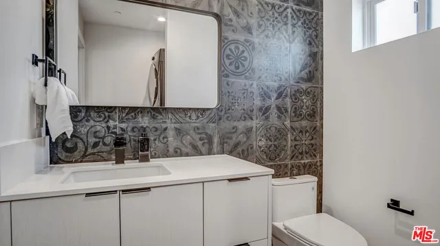 a bathroom with a sink a toilet and mirror