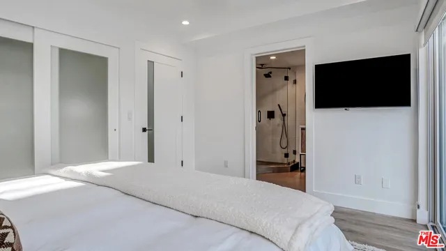 a bedroom with a bed and a flat screen tv