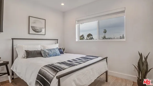 a bedroom with a bed and a painting on the wall