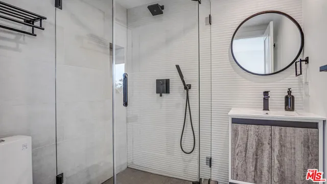 a bathroom with a mirror a shower and a sink