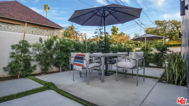 a view of a patio with table and chairs under an umbrella