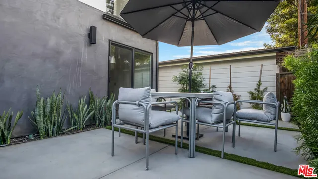 a view of a patio with a table and chairs under an umbrella