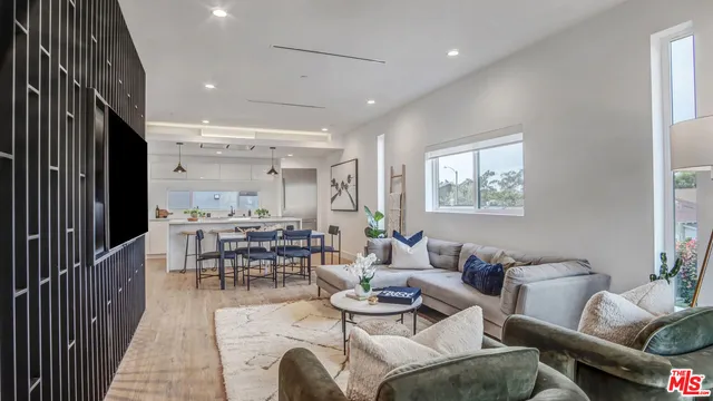 a living room with furniture and a dining table with wooden floor