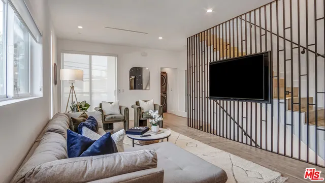 a living room with furniture tv and a window