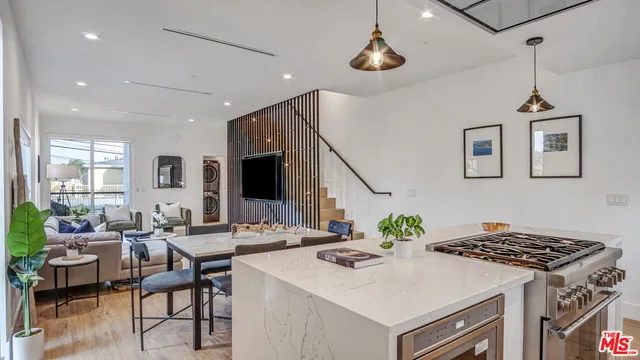 a view of kitchen island a sink and a stove