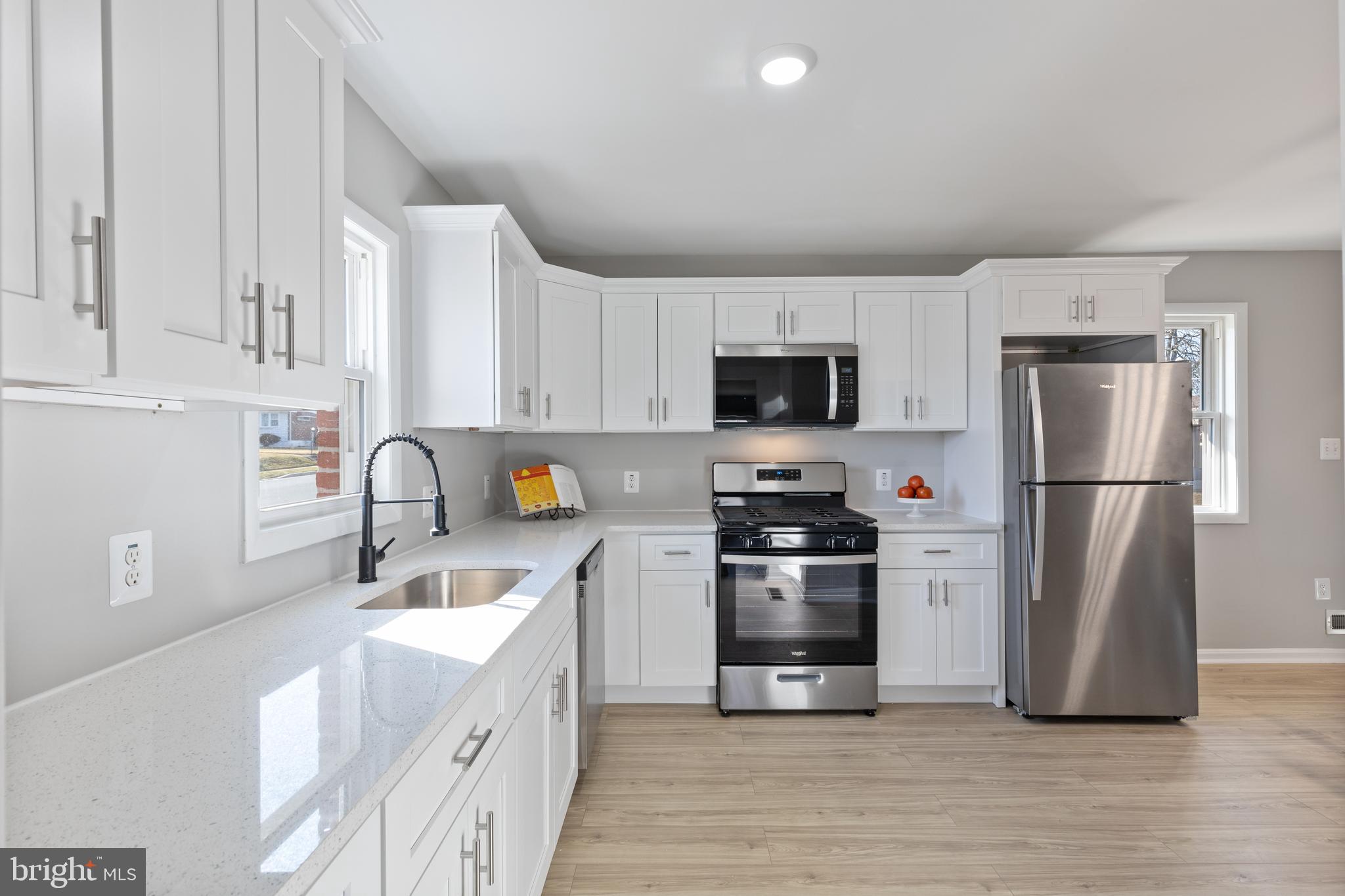 a kitchen with stainless steel appliances granite countertop a refrigerator stove a sink and a microwave