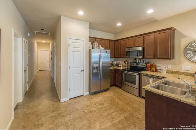 a kitchen with granite countertop a refrigerator and a sink