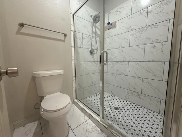 a bathroom with a toilet and a shower