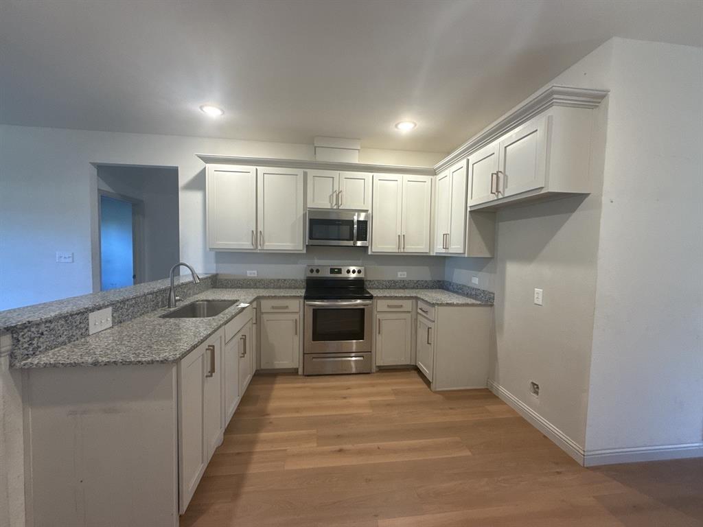 129 Towering Oaks Tool, TX 75143 - Photo 4 of 20 a kitchen with granite countertop a sink stainless steel appliances and cabinets