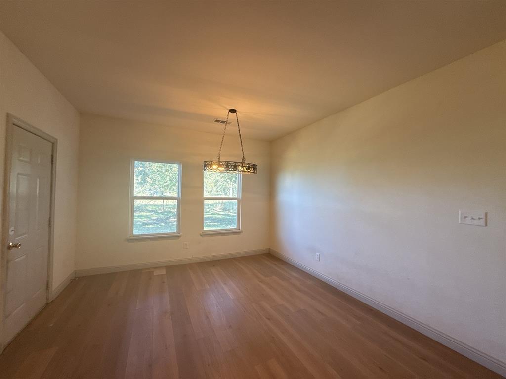 129 Towering Oaks Tool, TX 75143 - Photo 5 of 20 a view of an empty room with wooden floor and a window
