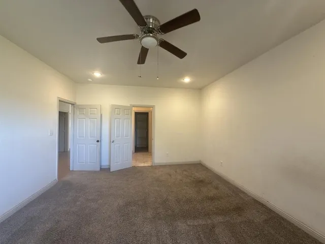 an empty room with a ceiling fan and fan