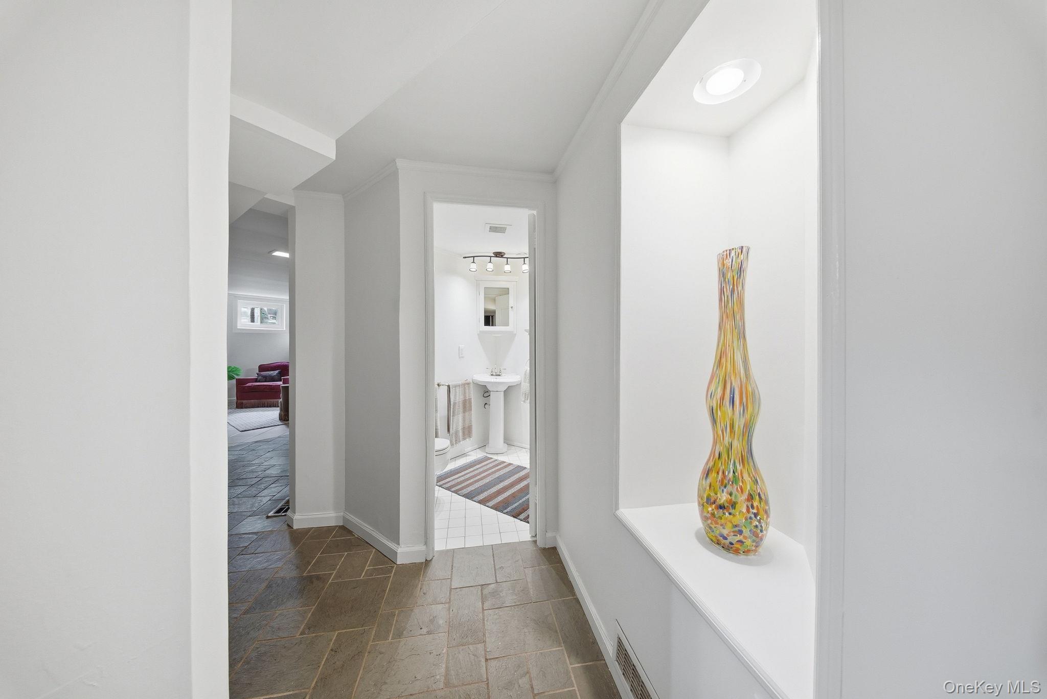 172 Wards Road Livingston Manor, NY 12758 - Photo 37 of 47 Hallway featuring stone tile flooring, a recessed wall niche with integrated lighting, and white baseboard trim
