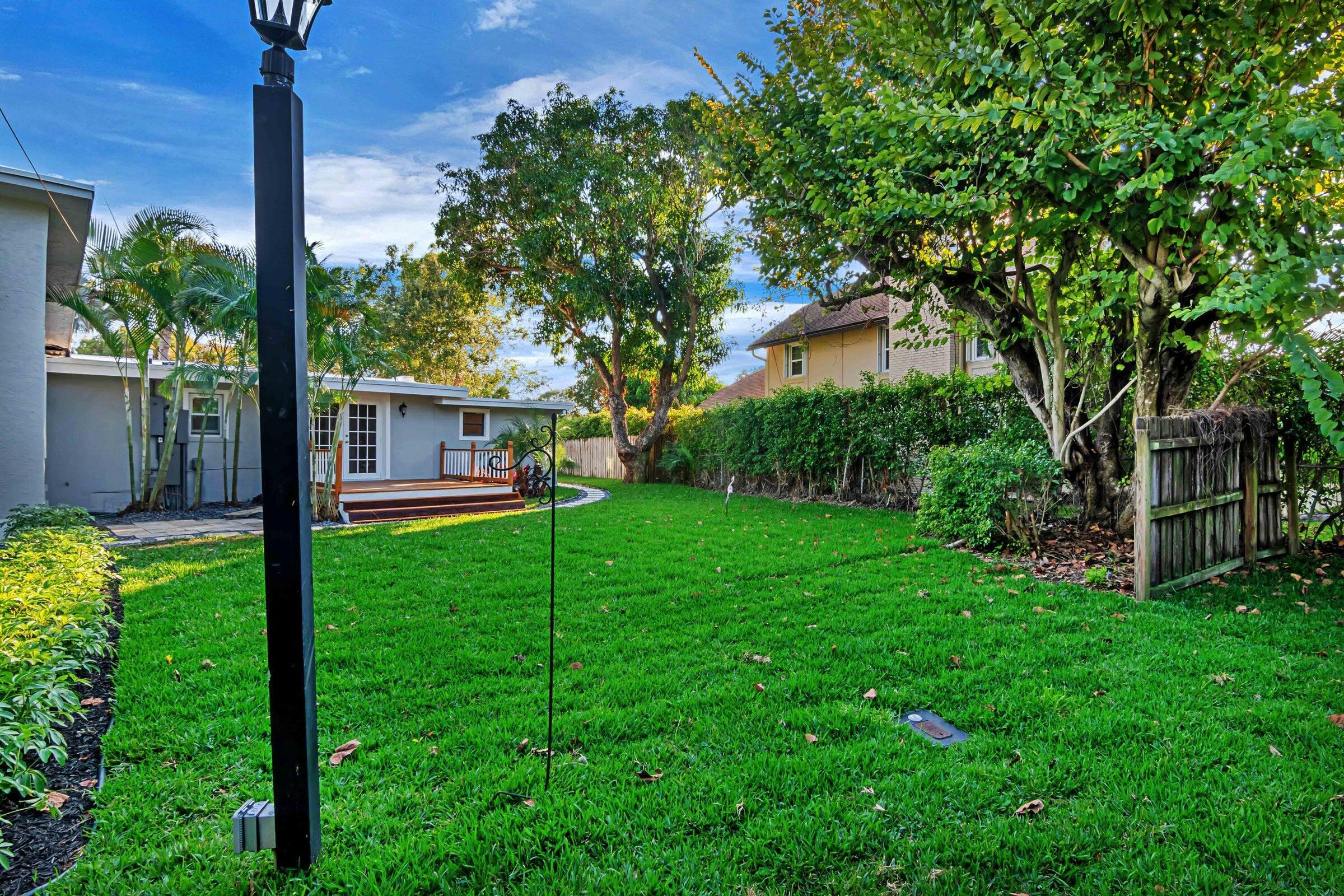 959 Southwest 18th Street, Unit W Boca Raton, FL 33486 - Photo 15 of 18 a view of a house with backyard and a tree