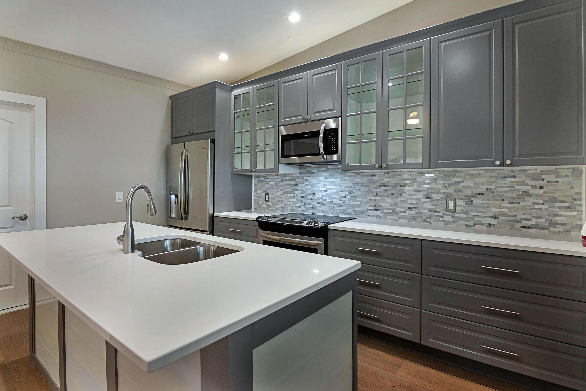 959 Southwest 18th Street, Unit W Boca Raton, FL 33486 - Photo 4 of 18 a kitchen with stainless steel appliances granite countertop a sink and a refrigerator