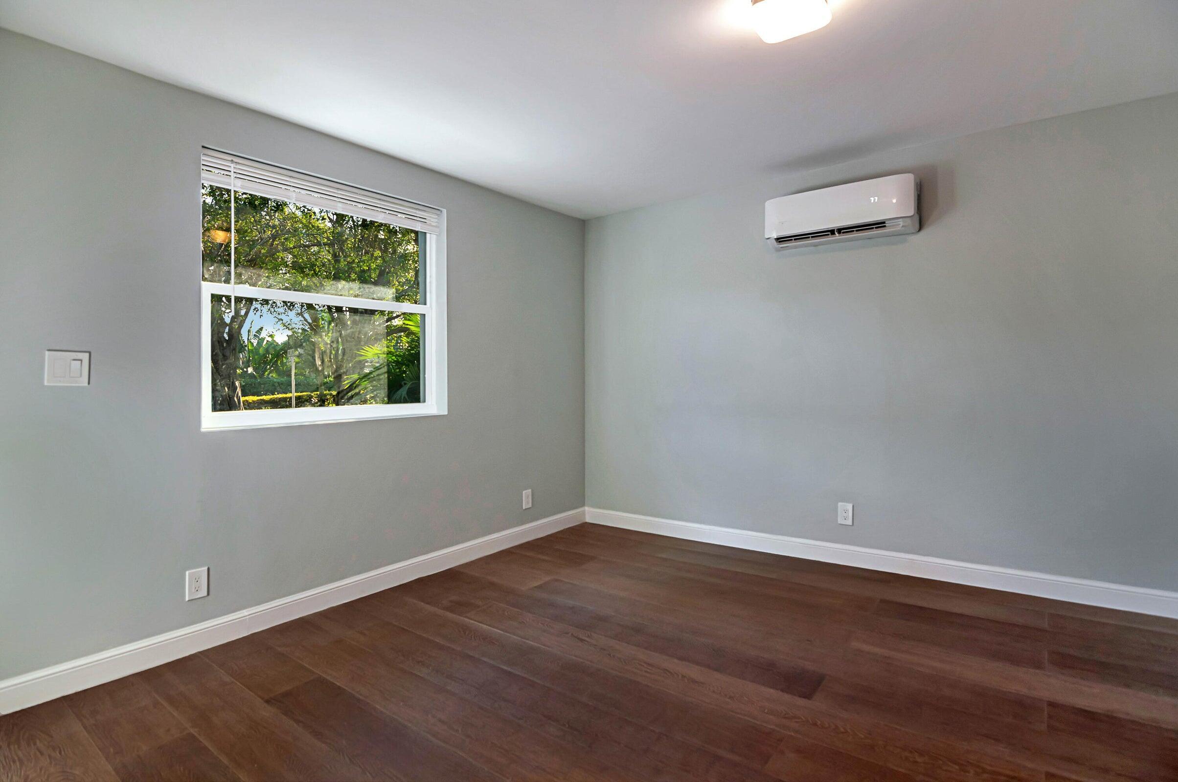 959 Southwest 18th Street, Unit W Boca Raton, FL 33486 - Photo 6 of 18 a view of an empty room with wooden floor and a window