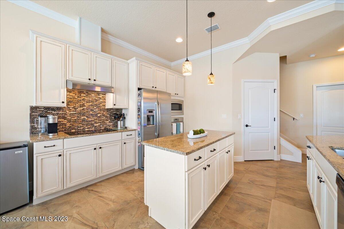 671 Palm Drive Satellite Beach, FL 32937 - Photo 13 of 69 a kitchen with granite countertop a stove oven and white cabinets