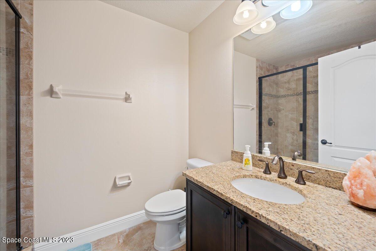 671 Palm Drive Satellite Beach, FL 32937 - Photo 27 of 69 a bathroom with a granite countertop sink a toilet and a mirror
