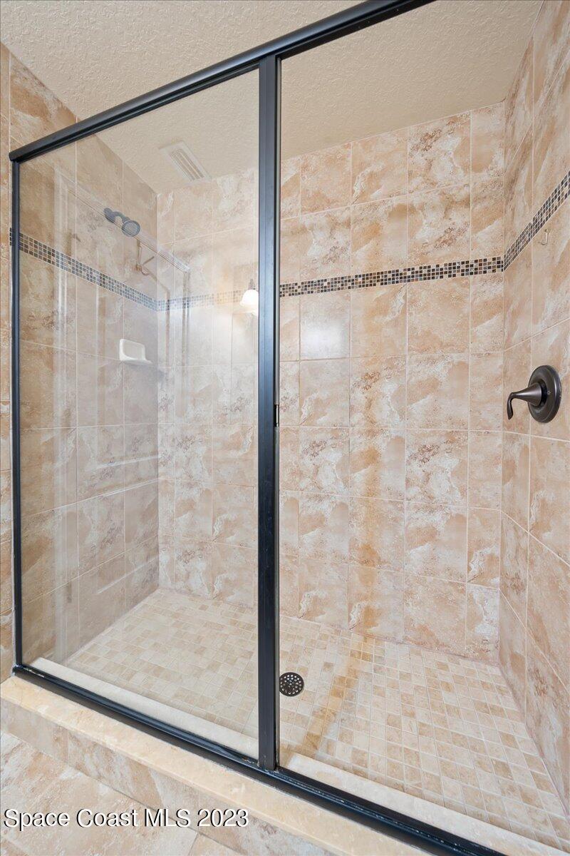 671 Palm Drive Satellite Beach, FL 32937 - Photo 28 of 69 a bathroom with a glass shower door