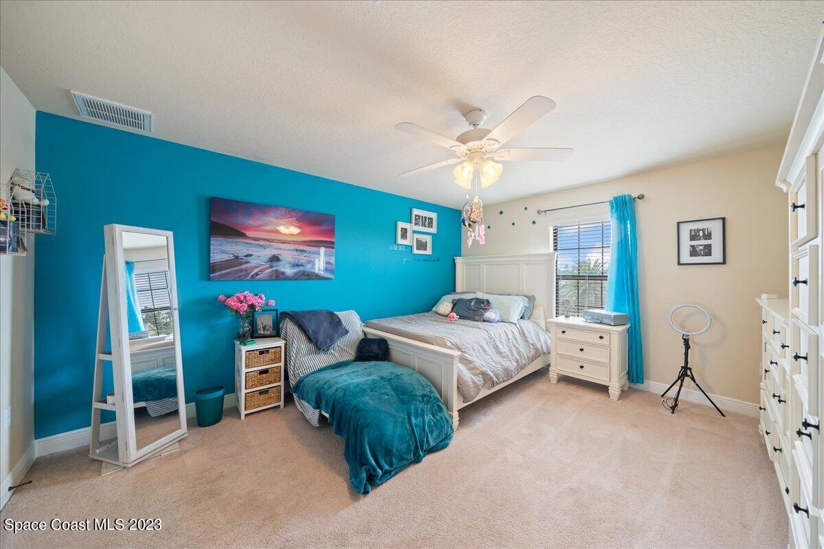 671 Palm Drive Satellite Beach, FL 32937 - Photo 33 of 69 a bedroom with bed and a chandelier