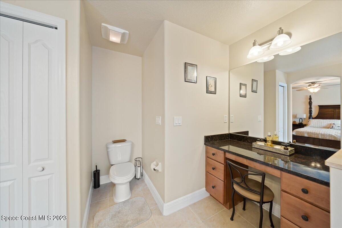 671 Palm Drive Satellite Beach, FL 32937 - Photo 55 of 69 a bathroom with a granite countertop sink a toilet and a mirror
