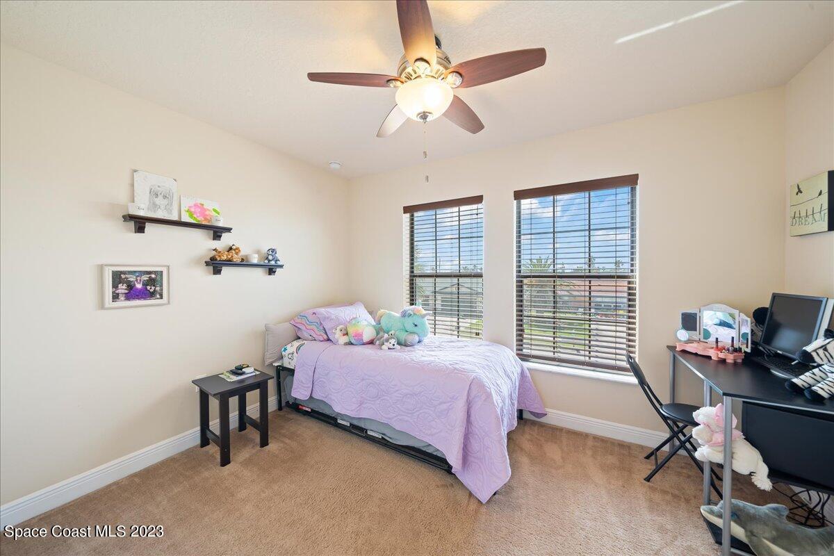 671 Palm Drive Satellite Beach, FL 32937 - Photo 57 of 69 a bedroom with a bed a desk chair and windows