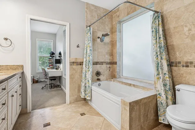 a bathroom with a granite countertop sink toilet and shower