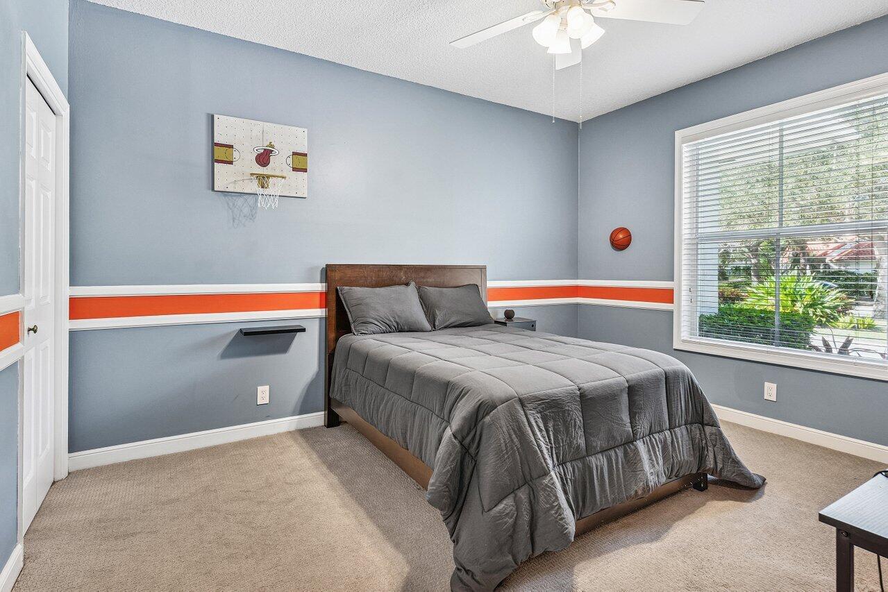 2450 Northwest 41st Street Boca Raton, FL 33431 - Photo 26 of 62 a bedroom with a bed and a painting on the wall