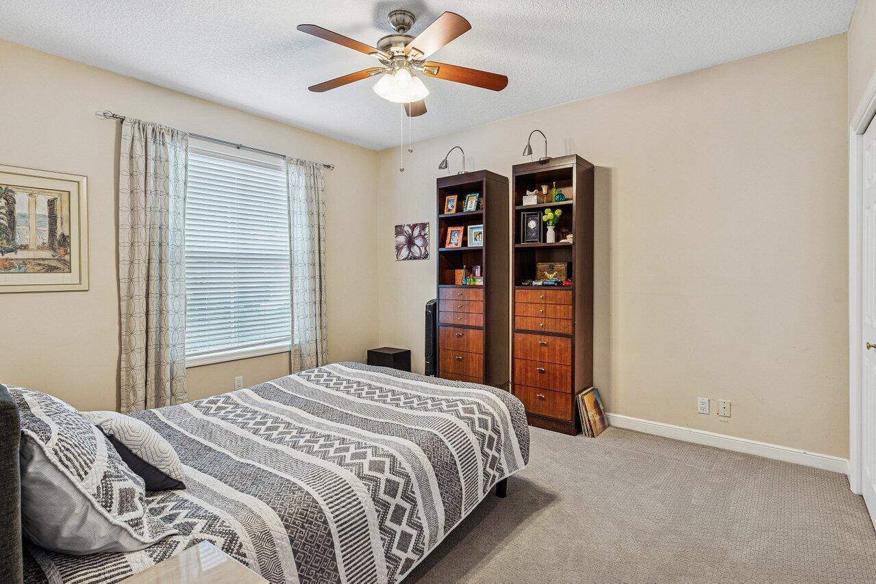 2450 Northwest 41st Street Boca Raton, FL 33431 - Photo 28 of 62 a bedroom with a large bed and a chandelier