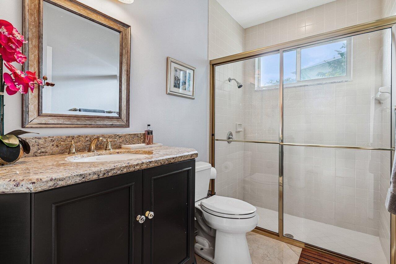 2450 Northwest 41st Street Boca Raton, FL 33431 - Photo 31 of 62 a bathroom with a granite countertop sink toilet and shower