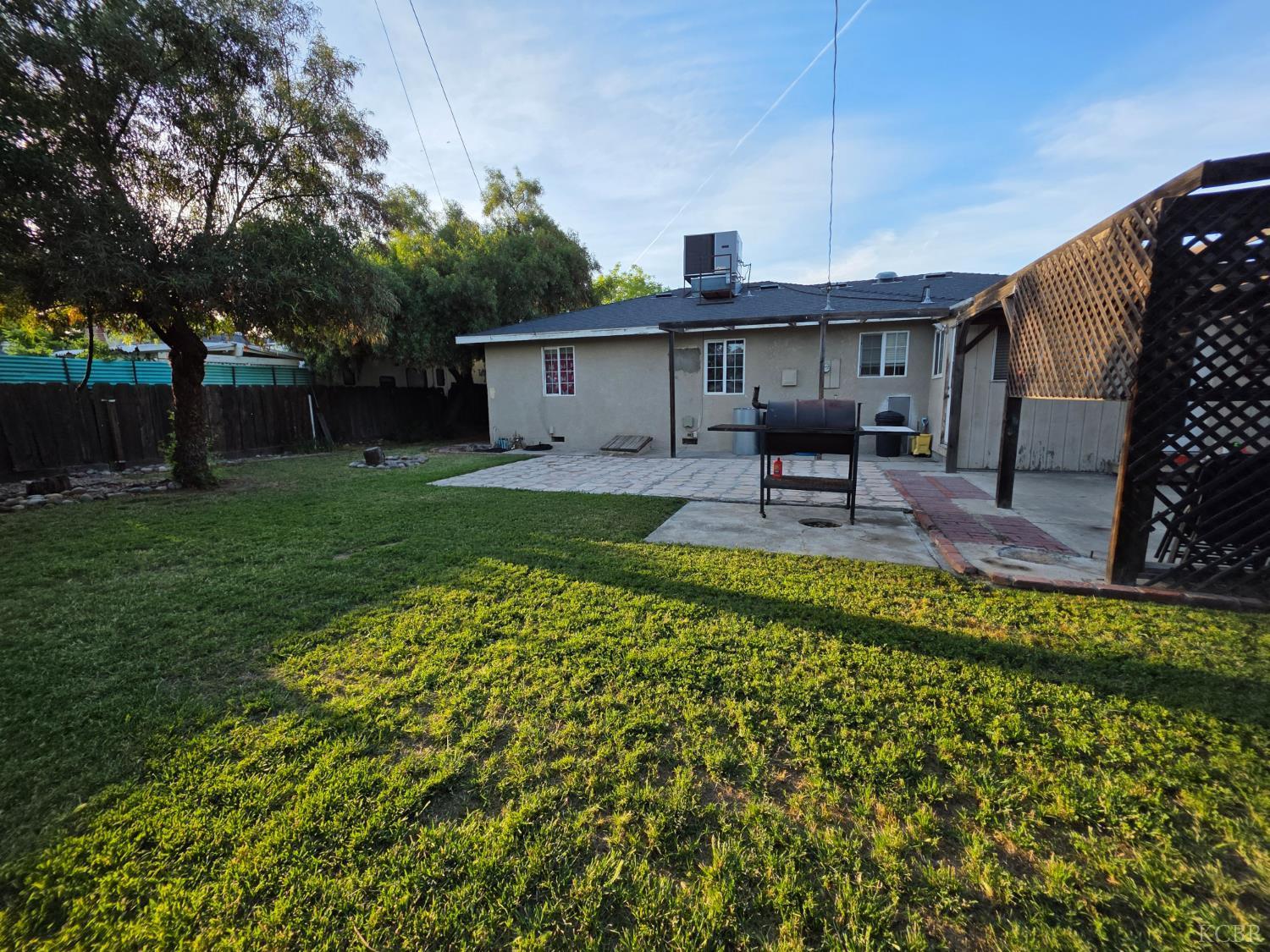 275 Ida Way Hanford, CA 93230 - Photo 18 of 21 a view of a patio with table and chairs potted plants and large tree
