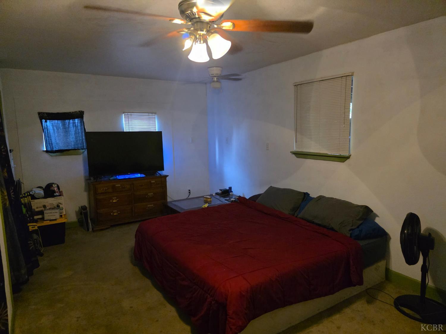 275 Ida Way Hanford, CA 93230 - Photo 9 of 21 a bedroom with a bed and a flat tv screen on the dresser