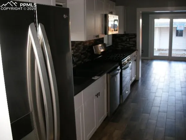 a kitchen with stainless steel appliances granite countertop a refrigerator and a sink